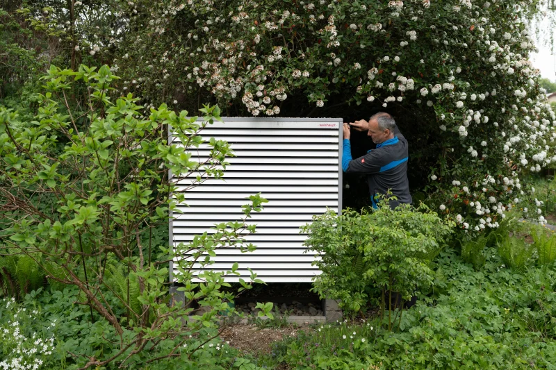 Mitarbeiter an der Wärmepumpe im Garten