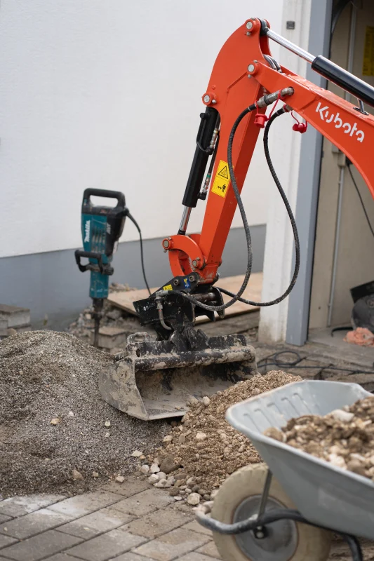 Minibagger und Material auf der Baustelle